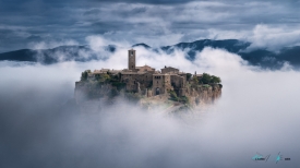 view of Civita di Bagnoregio among clouds italy